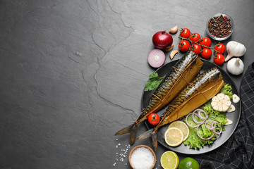 Flat lay composition with tasty smoked fish on dark table, space for text
