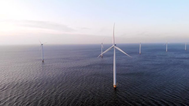aerial view at windmill park during sunset in the Netherlands, green energy wind mill turbines