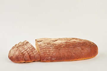 Black bread on white background. Sliced dark loaf of bread. Space for text.