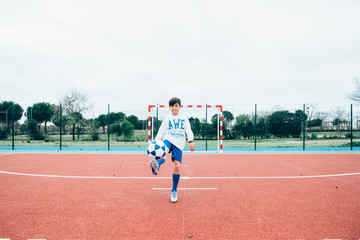 Soccer player boy hitting the ball