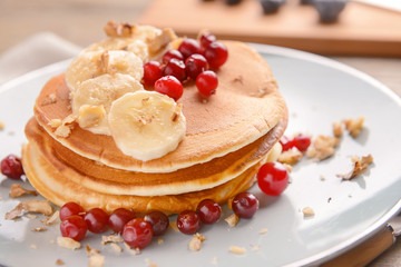 Plate with tasty sweet pancakes on table, closeup