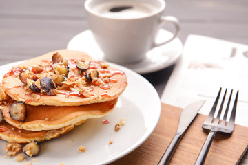 Plate with tasty sweet pancakes on table, closeup