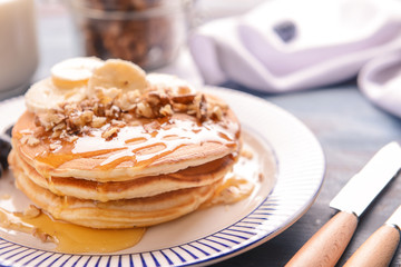 Fototapeta na wymiar Plate with tasty sweet pancakes on table, closeup