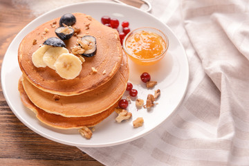 Obraz na płótnie Canvas Plate with tasty sweet pancakes on wooden table
