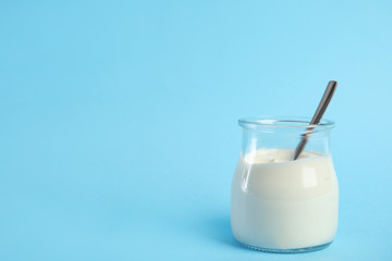 Tasty organic yogurt on light blue background. Space for text
