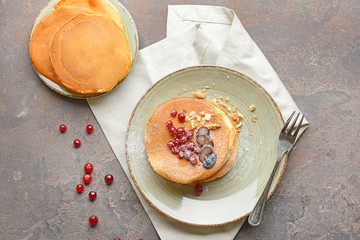 Plates with tasty sweet pancakes on grunge background