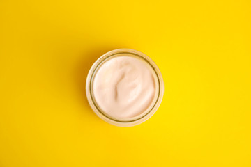 Tasty organic yogurt on yellow background, top view