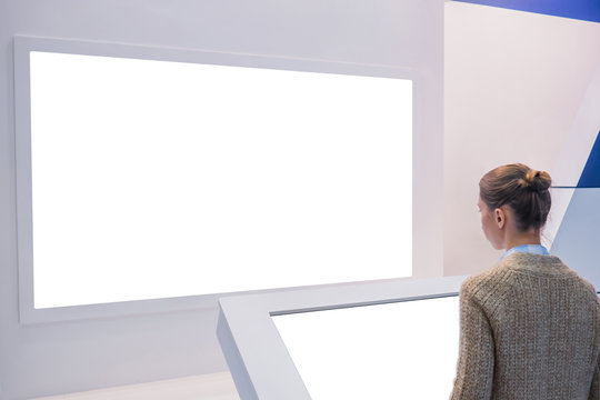White screen, mock up, future, copyspace, template, isolated, technology concept. Woman looking at blank digital interactive white display wall at exhibition or museum with futuristic scifi interior