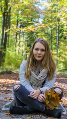 Fotoshooting mit einer h&uuml;bschen jungen Frau im Wald in der Herbstzeit - verspielte Bilder mit Herbstbl&auml;ttern