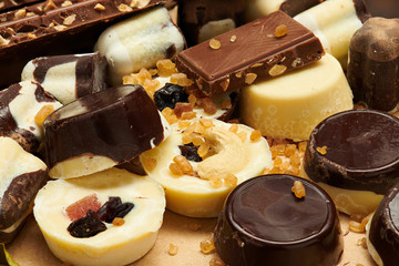 Chocolate bars and homemade candies on rustic table, sweet food, macro photo