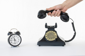 Clock time picking up the phone black rotary telephone white isolated background