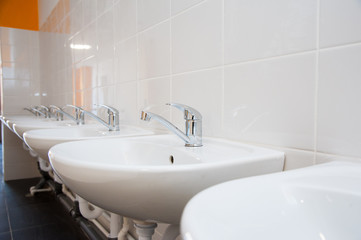 Close-up of row modern ceramic wash hand basins
