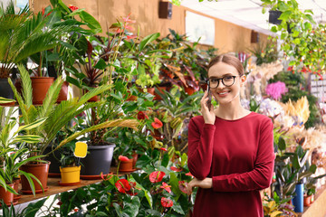 Female business owner talking on mobile phone in flower shop