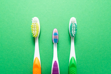 plastic colored toothbrushes on green background