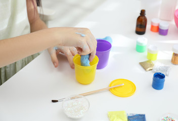 Obraz na płótnie Canvas Little girl making DIY slime toy at table, closeup