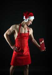 Best Christmas gift for fitness, wellness and sports lovers. Strong man hold gift box. Athletic cook with Christmas gift. St. Nicholas feast. Boxing day. New year present. Gift from Santa