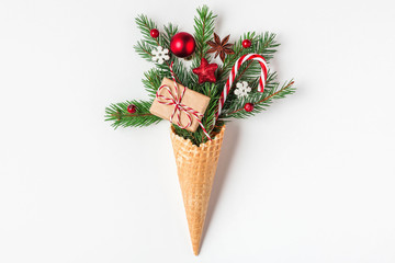Christmas concept. fir tree branches, gift box and Christmas decorations in waffle ice cream cone...
