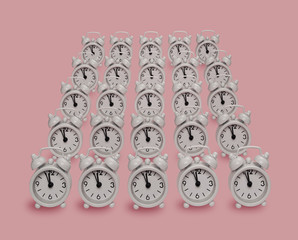 Summer sunlight pattern made with a white clock on a bright pink background. The concept of minimum time.