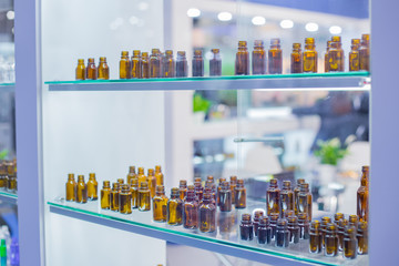 Medical empty glass brown bottles in showcase at pharmaceutical exhibition, pharmacy laboratory....