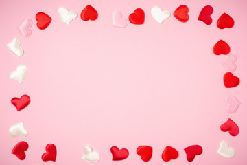 Red hearts for Valentine's day lie on a beautiful pink background. Heart pendant. Space for text. Red heart. Valentine Day.