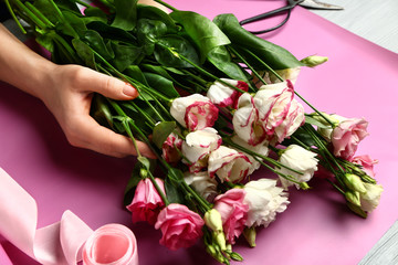 Female florist making beautiful bouquet at table