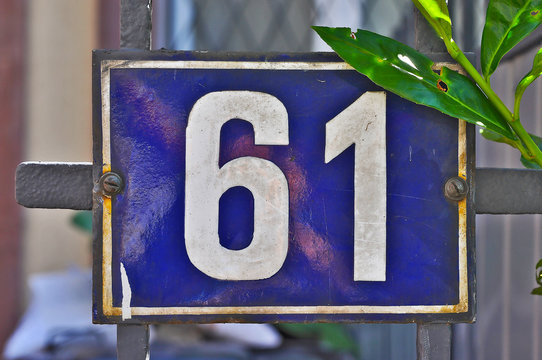 A house number plaque, showing the number sixty one (61)
