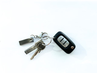 Car key next to house key and flash disc