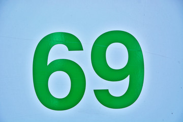 A house number plaque, showing the number sixty nine (69)