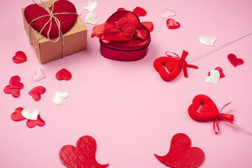 Red hearts with a gift to Valentine's Day on a beautiful pink background. Heart pendant. Space for...