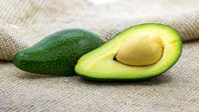 Two halves of avocado on burlap. Foods rich in vitamins_