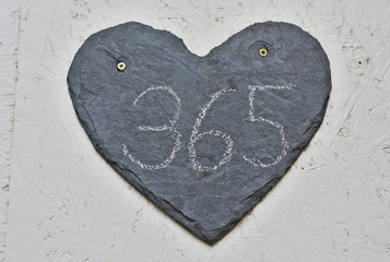 A heart shaped, house number plaque, showing the number three hundred sixty five (365) 