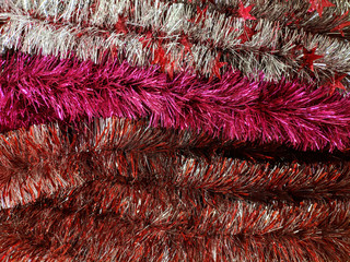 Pink and red Christmas tinsel. Multi-colored decorations for the celebration of the new year. Texture.