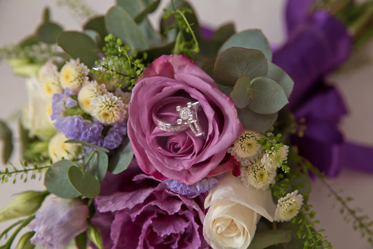 coloured macro photo of a detailed bouquet with pink roses, white small flowers and a fake diamond in the centre of the rose