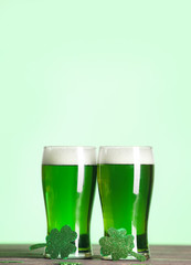 Glasses of green beer and clover on table. St. Patrick's Day celebration