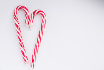 Christmas candy on a white background in the form of a heart, with free space for writing