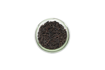 glass jar with large black tea, top view. Isolated on the white background