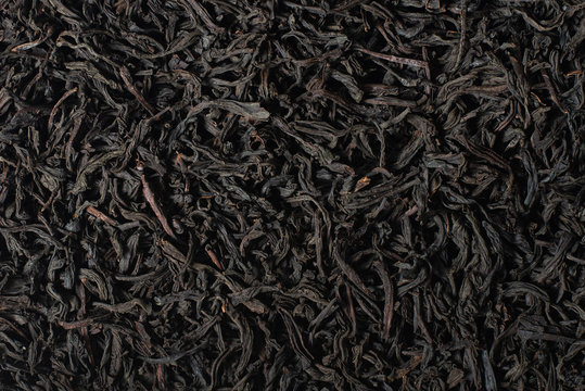 Leaf black tea. Large leaves of black tea background, close up.