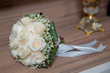 Wedding bouquet of white roses on a wooden table. top view . Beautiful wedding bouquet of white roses.