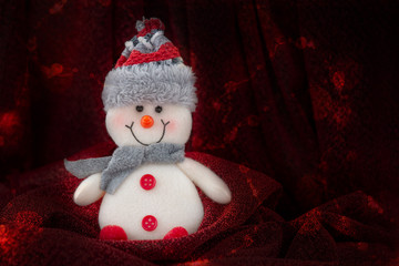 Christmas, new year background. There is a white and red cheerful snowman on a red background