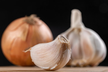 Fresh onion and garlic on a kitchen chopping board. Healthy vegetables on a table in a home kitchen.