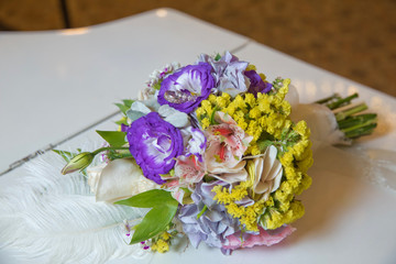 coloured macro photo of a detailed bouquet with pink roses, white small flowers and a fake diamond in the centre of the rose