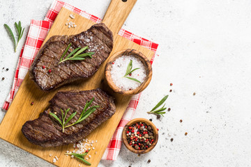 Grilled beef steak on wooden cutting board.