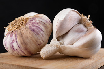 Fresh garlic on a kitchen chopping board. Healthy vegetables on a table in a home kitchen.
