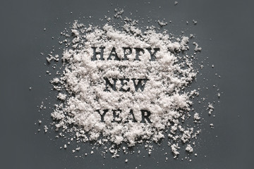 Text HAPPY NEW YEAR with snow on grey background