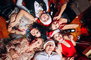 Group of friends at club having fun and lying on the floor .New years party