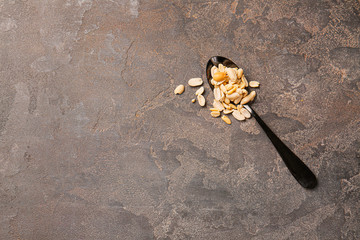 Spoon with peanuts on grunge background