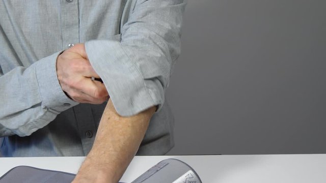 Man applies a blood pressure cuff 4K