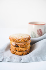 Stacked cookies on a linen napkin and a cup of coffee. Close up.