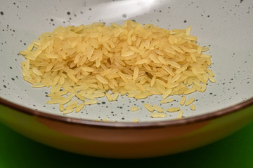 Reis, roh Reis in einer Schale, Roher Reis in einer Schale, Reiskörner, Nahrung, Grundnahrung  Parboild