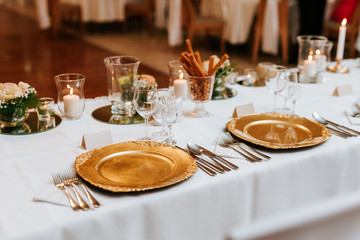 Decoration of a wedding, white flowers, candles and glasses for drinks